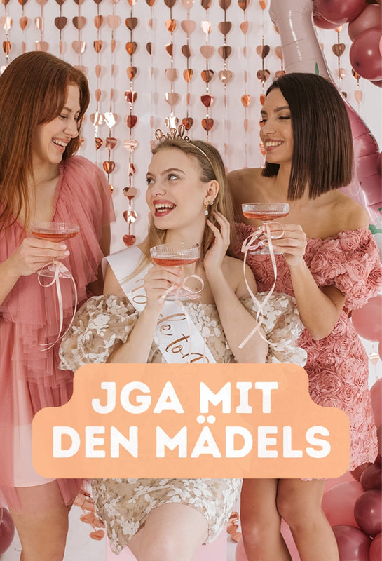 Drei junge Frauen feiern einen JGA mit Partydekoration